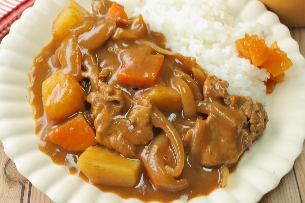 カレーライスのプレート。ご飯の隣にじゃがいも、にんじん、牛肉入りのカレーが盛り付けられている。