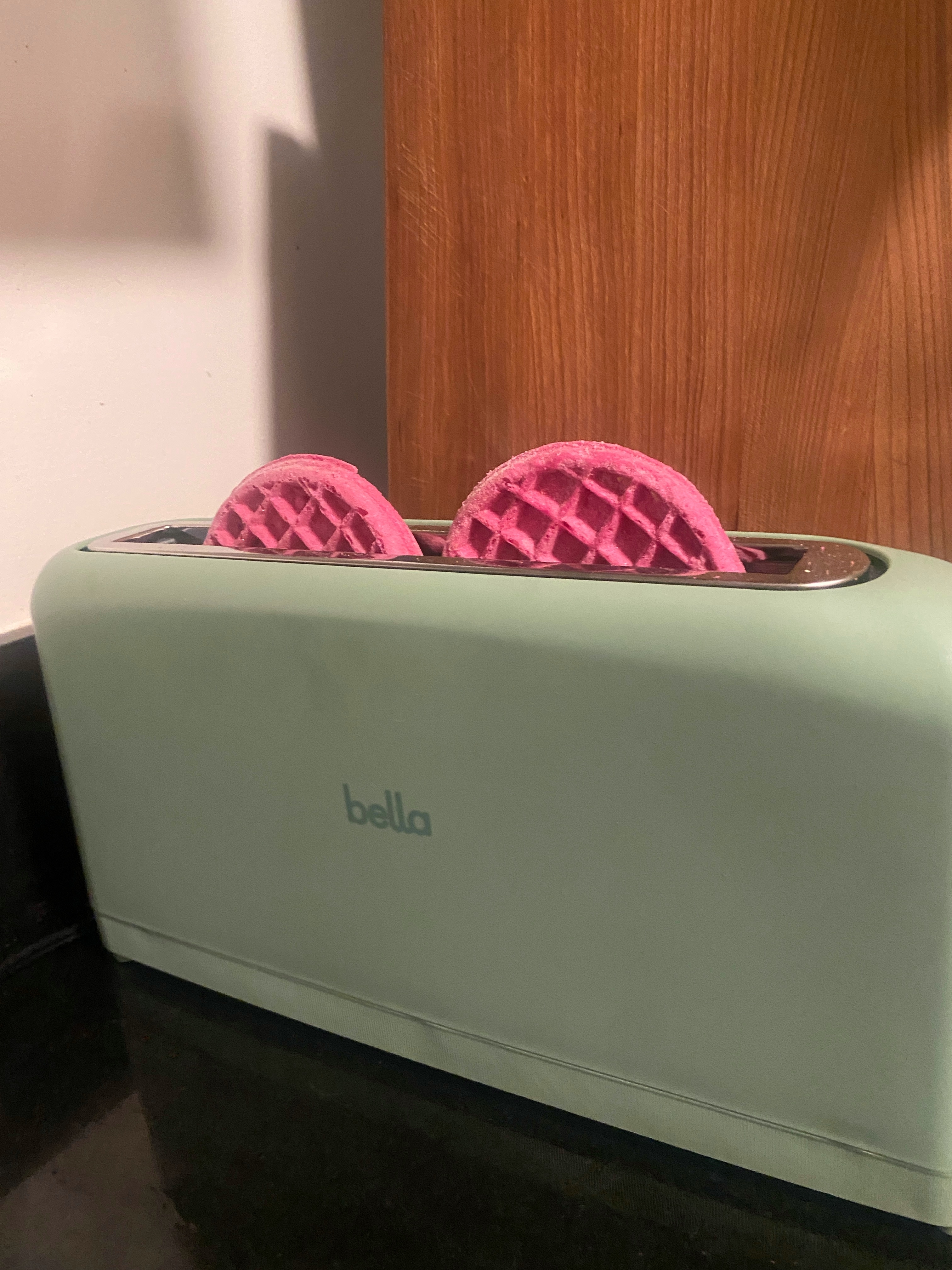 Toaster with two pink waffles partially visible