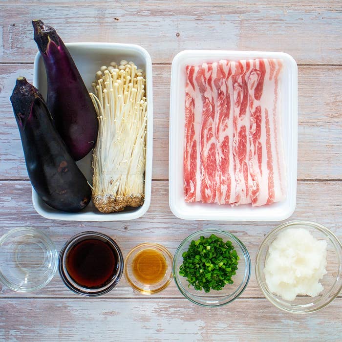 ナス、えのき、豚肉の薄切りがトレーに並び、ソースや薬味が小鉢に入っている調理準備の画像。