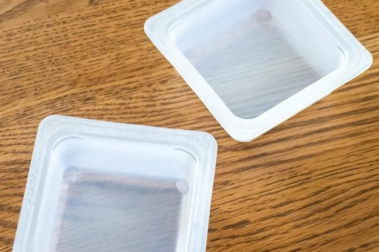 木製テーブルの上に置かれた、2つの透明なプラスチック容器。