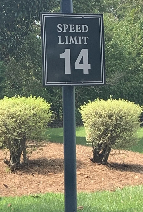 Speed bounds  motion   displaying "14" connected  a post, surrounded by neatly trimmed bushes
