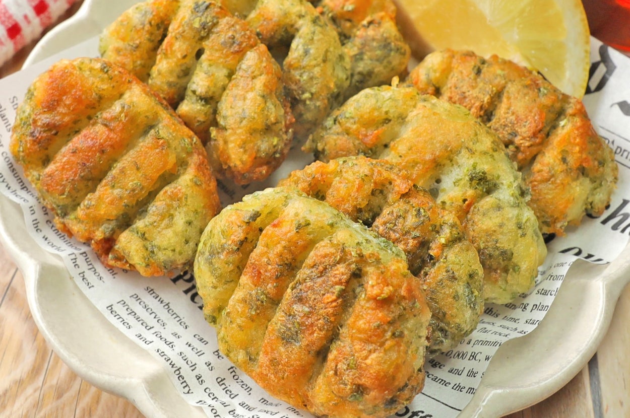 おいしそうな揚げ物料理が新聞紙にのり、レモンスライスが添えられている。