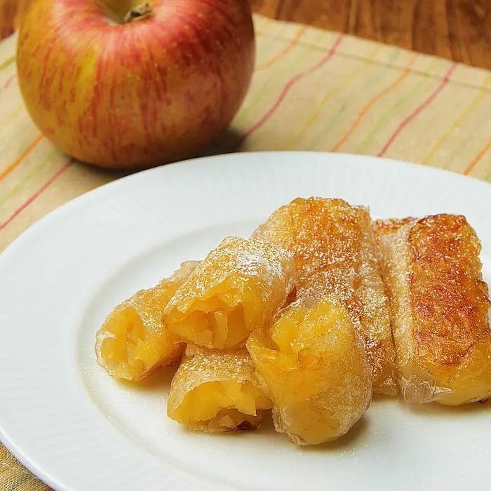 リンゴのそばに盛り付けられたアップルパイの春巻き風デザート。