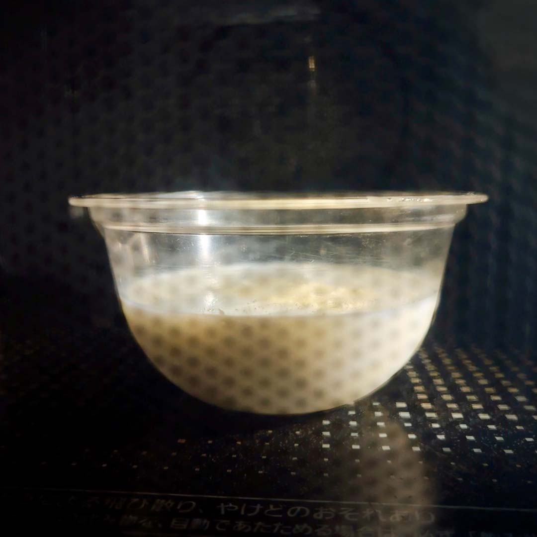 電子レンジ内にある透明容器に入った液体状の食材。