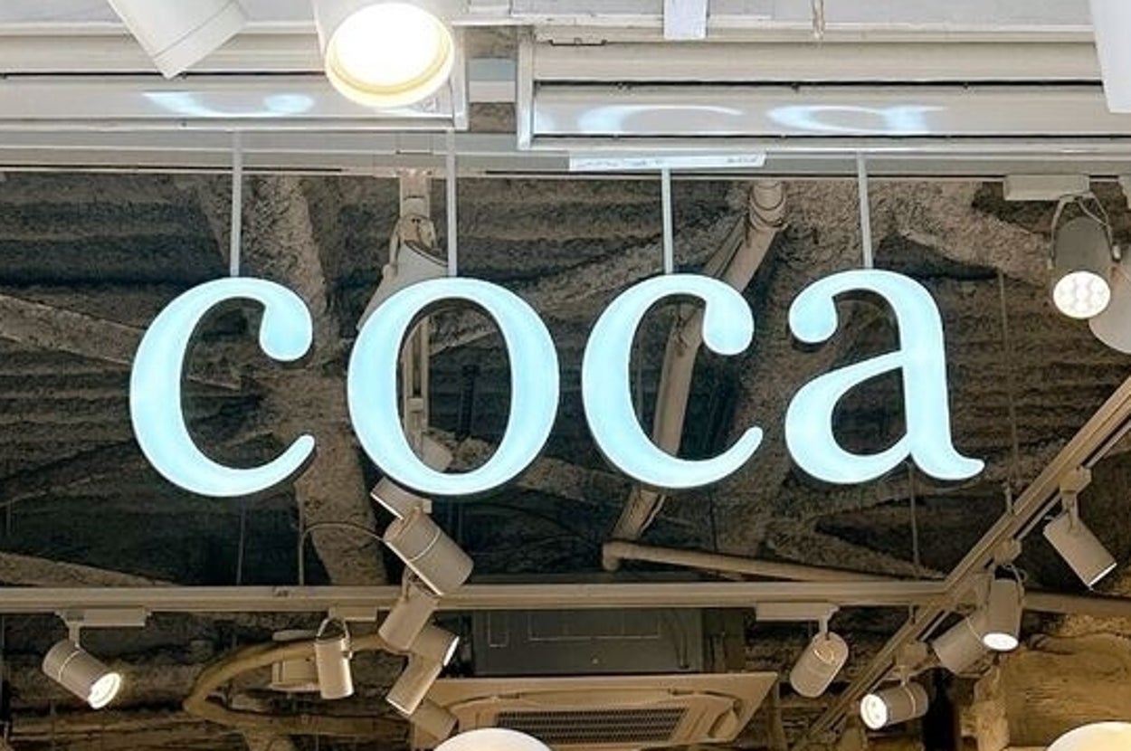 店の入口に「coca」と書かれたサイン。マネキンがディスプレイされています。