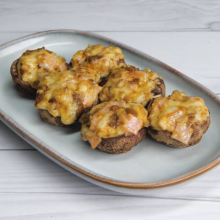 チーズとハムがトッピングされた焼きマッシュルームが6つ、プレートに乗っている。