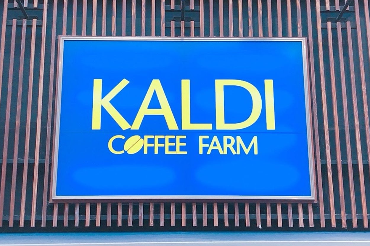 カフェ「KALDI COFFEE FARM」の看板が建物の外壁に掲げられている。下にスプリングマーケットの文字が見える。