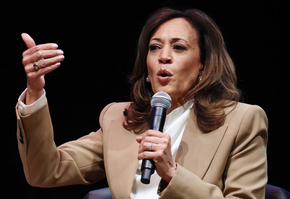 "I've Never Met You": Karoline Leavitt Was Truly Shocked By This Bold Question From The Latinos For Trump Founder 11 Person speaking on stage with a microphone, wearing a beige blazer and white shirt, gesturing with their hand during a discussion