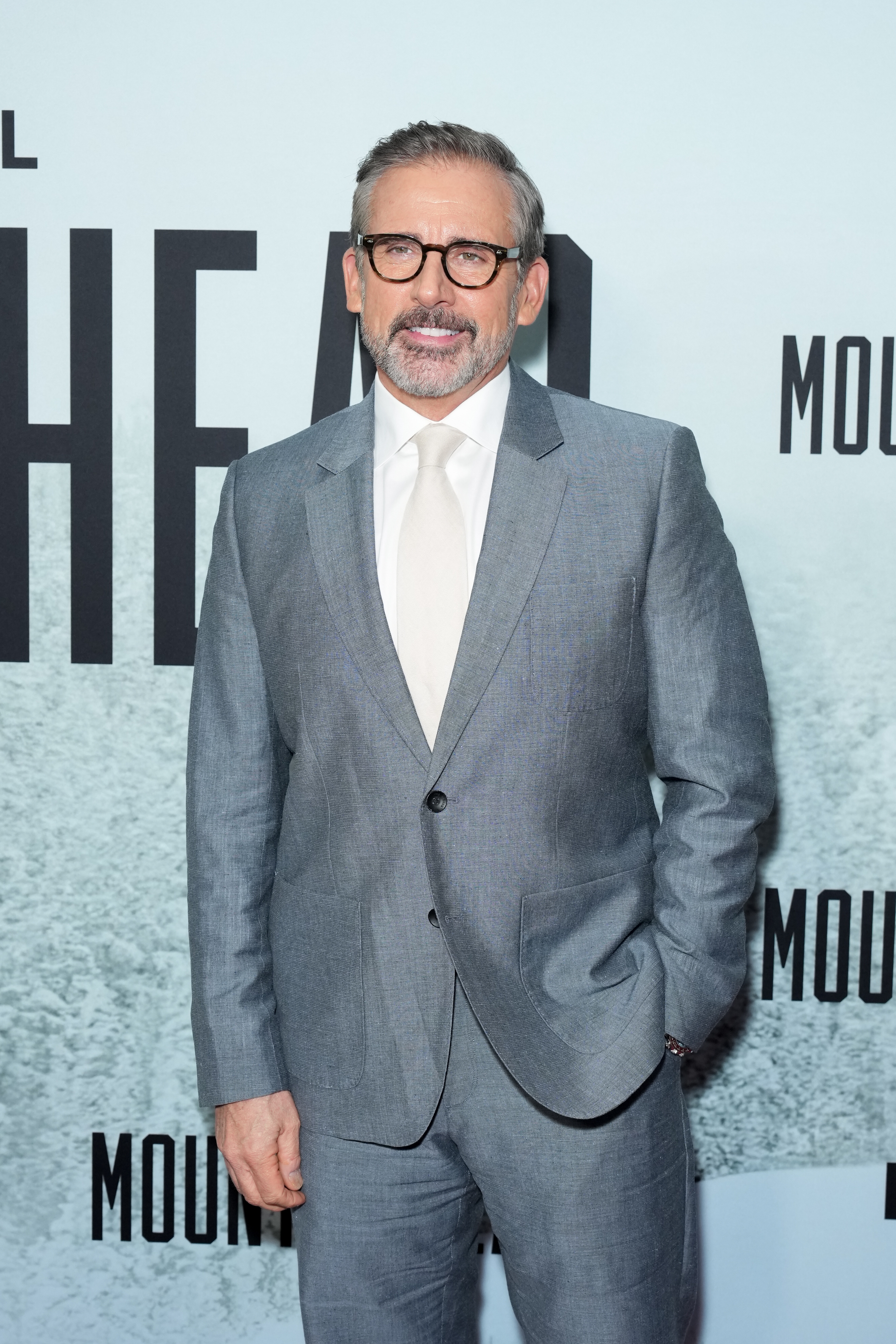 A idiosyncratic   successful  a tailored suit   with a achromatic  garment  and necktie  connected  a reddish  carpet, posing for a personage  event