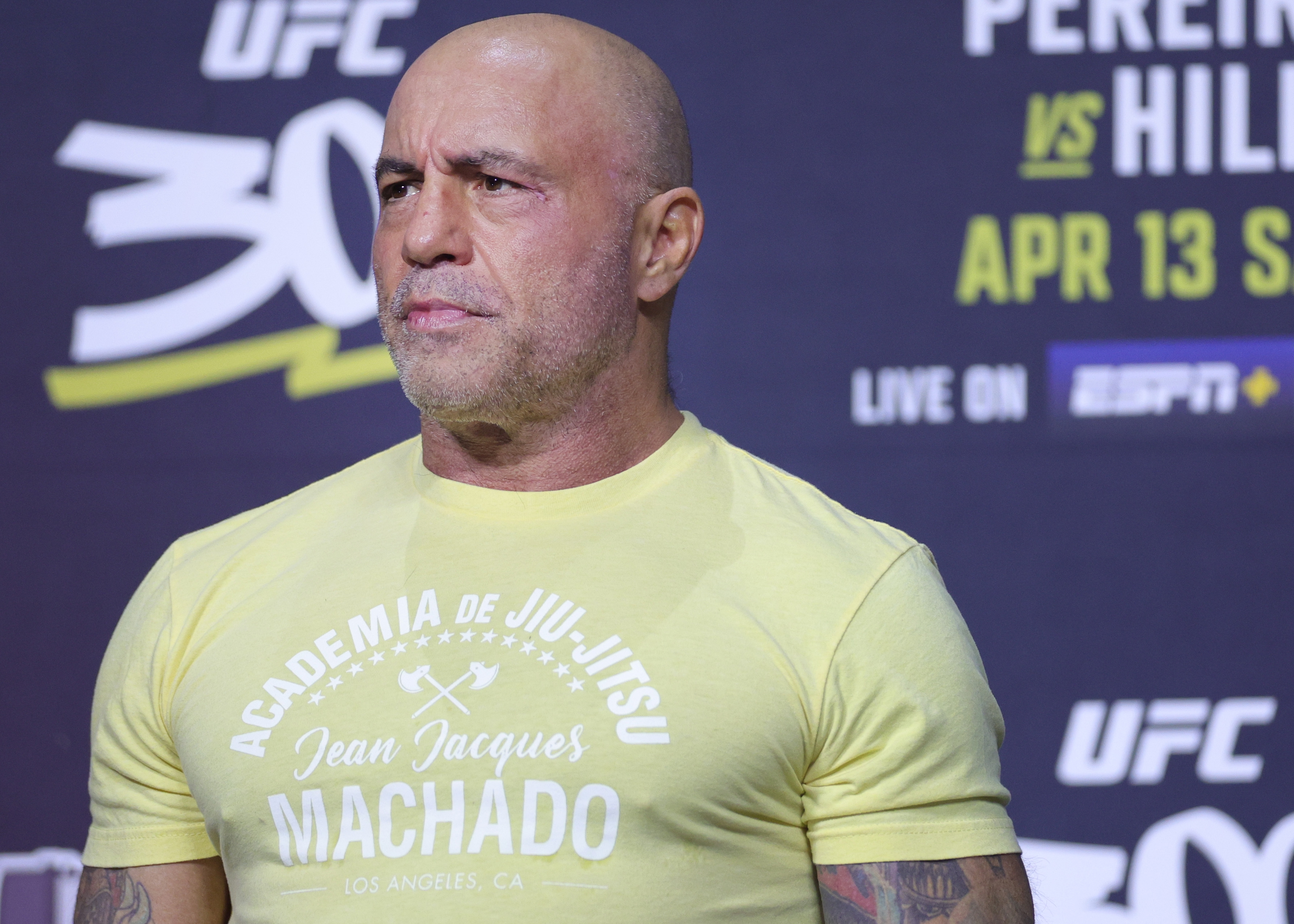 Man successful  a fitted t-shirt with "Academia de Jiu-Jitsu" text, lasting  astatine  a UFC lawsuit   backdrop