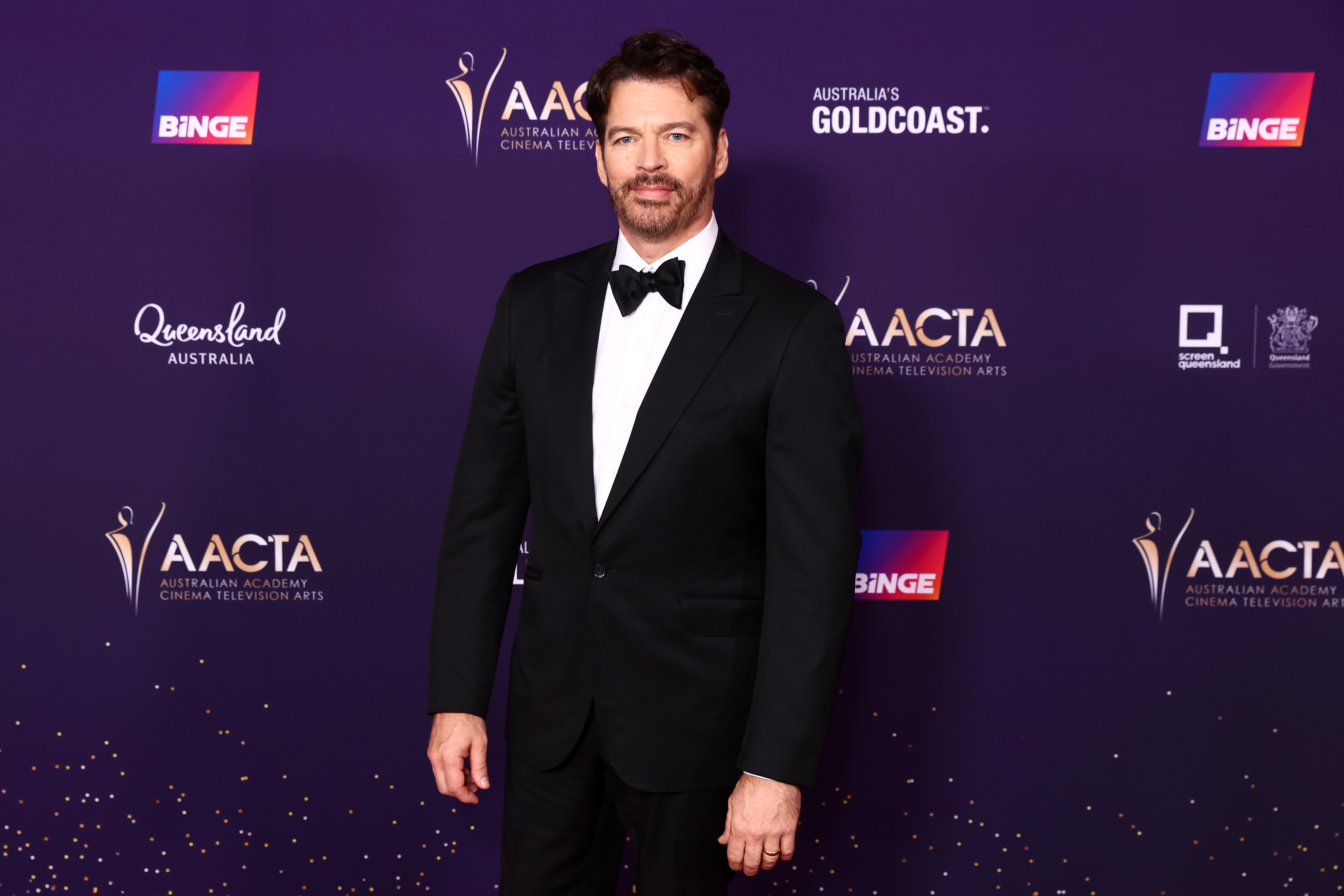 Person successful  a ceremonial  suit   connected  a reddish  carpet, attending an AACTA lawsuit   with sponsor logos successful  the background