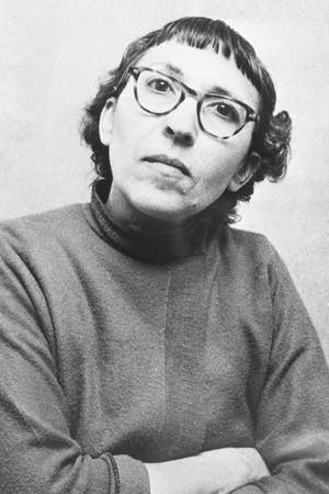 Person wearing glasses and a turtleneck, gazing upward thoughtfully