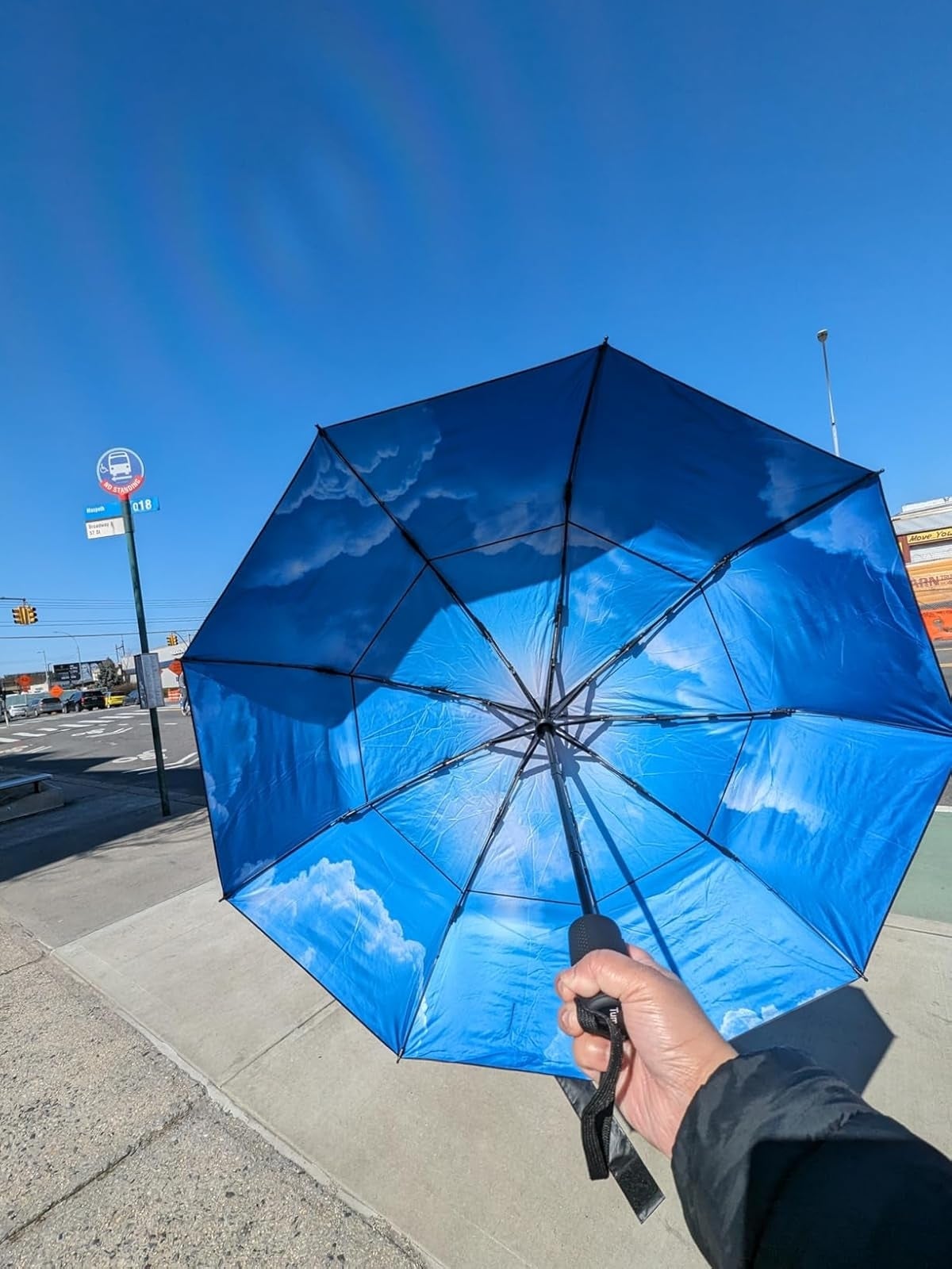 Person holding upside-down umbrella with clouds and entity  design, lasting  astatine  a autobus  halt  connected  a wide   day