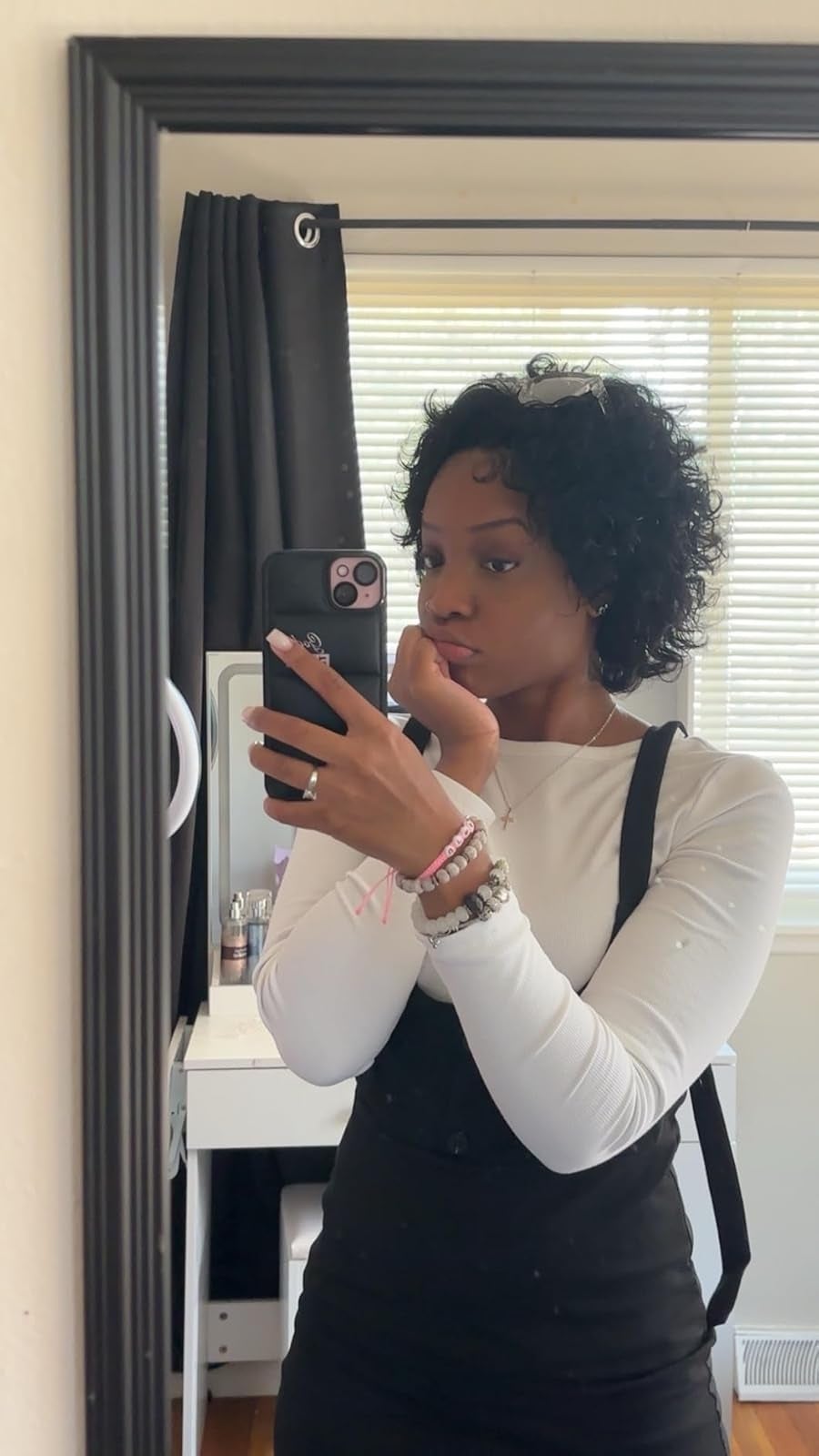 Person successful  a achromatic  apical  and achromatic  wide    takes a reflector  selfie successful  a country   with blinds, showcasing casual manner  style