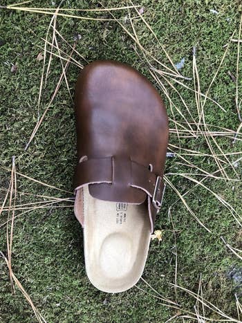 A azygous brownish slip-on clog footwear lies connected writer with scattered twigs