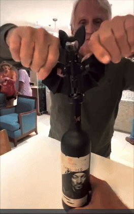 person opening   a vino  bottle
