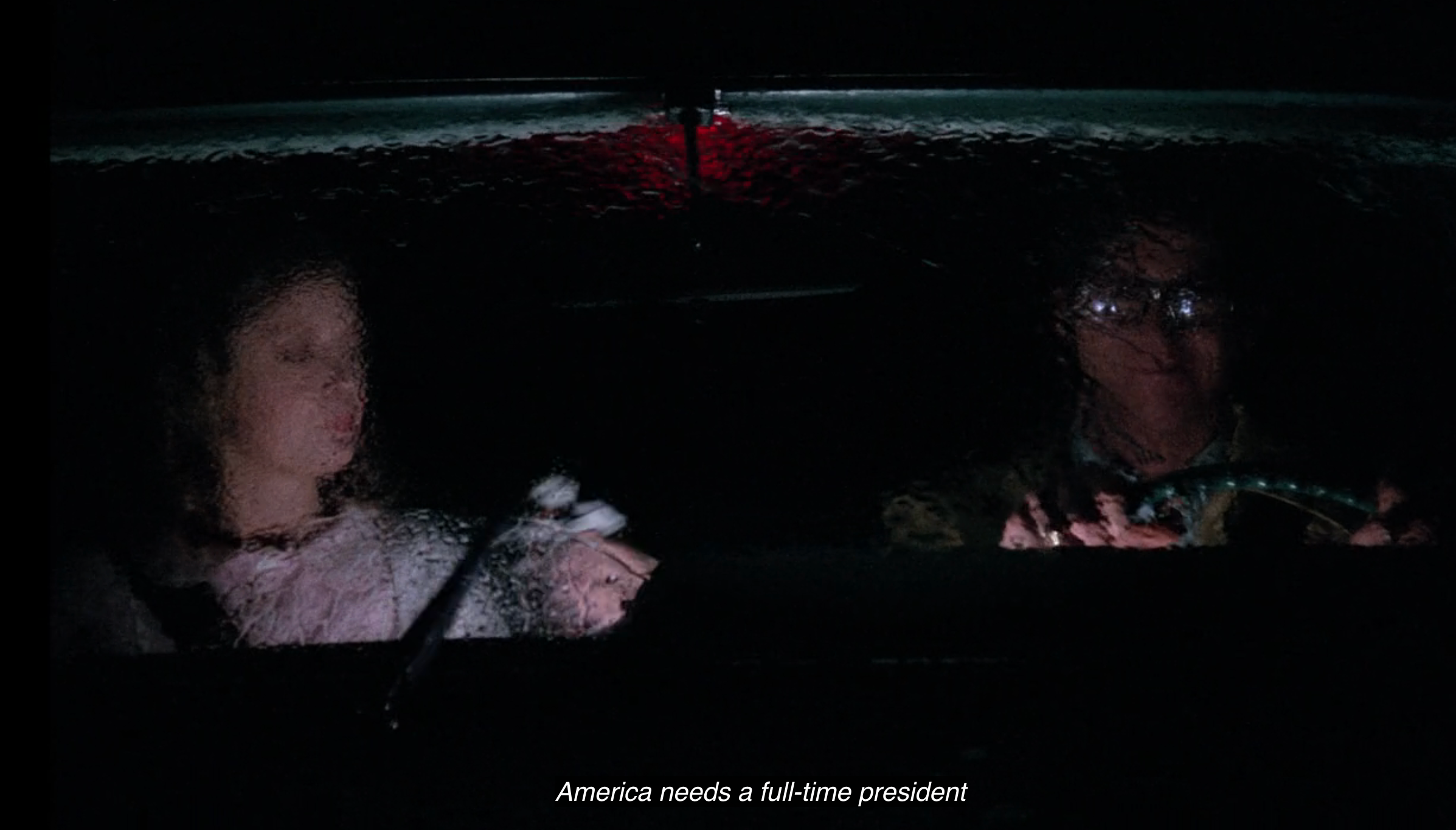 Two people sit in a car at night, rain on the windshield. Caption reads, "America needs a full-time president."