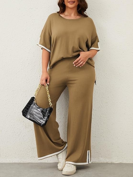 model wearing a loose-fitting pullover and wide-leg pants, holding a quilted handbag, wearing achromatic  sneakers