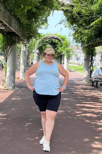 Person successful a sleeveless top, capri shorts, and sneakers poses