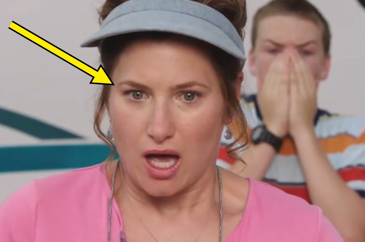 Woman in visor looks surprised, with a person in the background covering their face