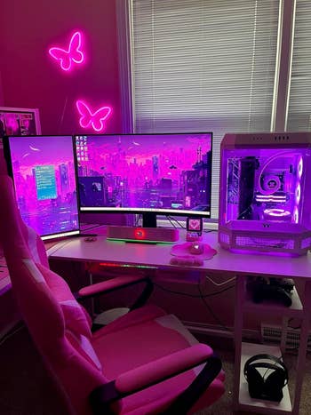 Futuristic gaming setup with dual monitors, neon butterfly lights, and glowing PC case, perfect for tech enthusiasts seeking immersive experiences