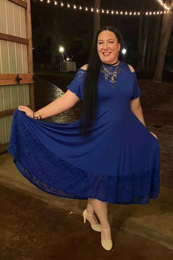Person smiling, wearing an elegant off-shoulder formal with lace details and beige heels