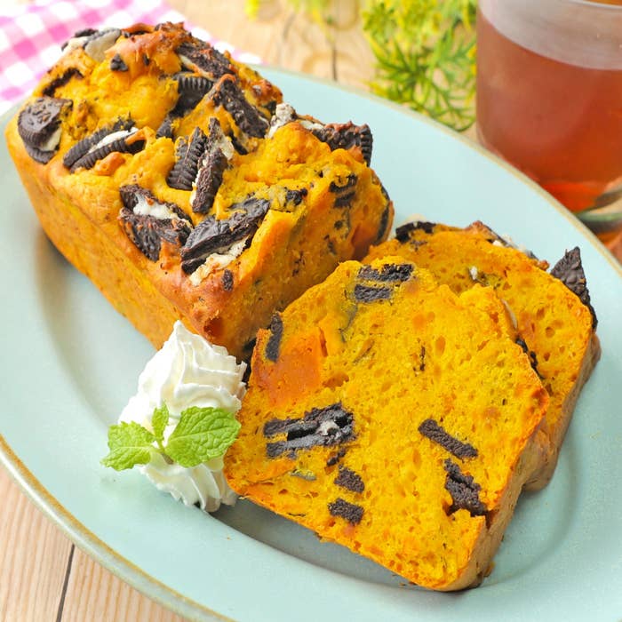 ケーキのスライスが皿に盛られ、ホイップクリームとミントが添えられている。上にはクッキーのトッピングがある。