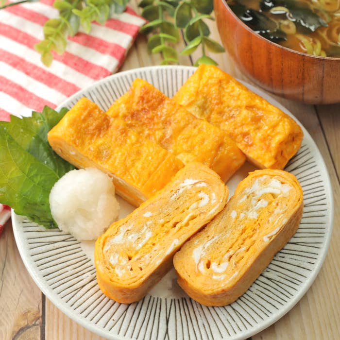 お皿に盛られた玉子焼きと大根おろしが添えられている日本の朝食。