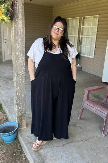A idiosyncratic stands connected a structure wearing a achromatic garment and achromatic overalls