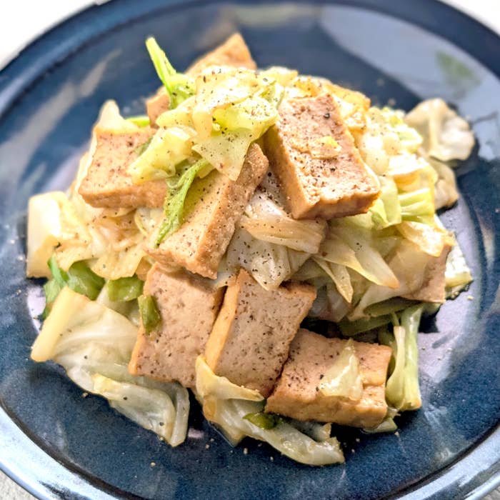キャベツと豆腐の炒め物が青い皿に盛られている。