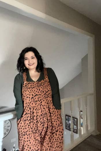 Person successful a leopard-print jumpsuit stands successful a hallway