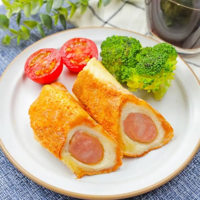 皿の上にソーセージを巻いた食パン、トマト、ブロッコリー。