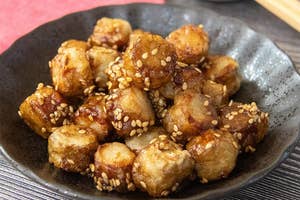 ゴマがまぶされた一口サイズの揚げ物が皿に盛られている。