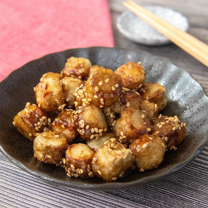 白いりごまがまぶされ、めんつゆで味付けされた一口サイズのごぼうの唐揚げが皿に盛られている。