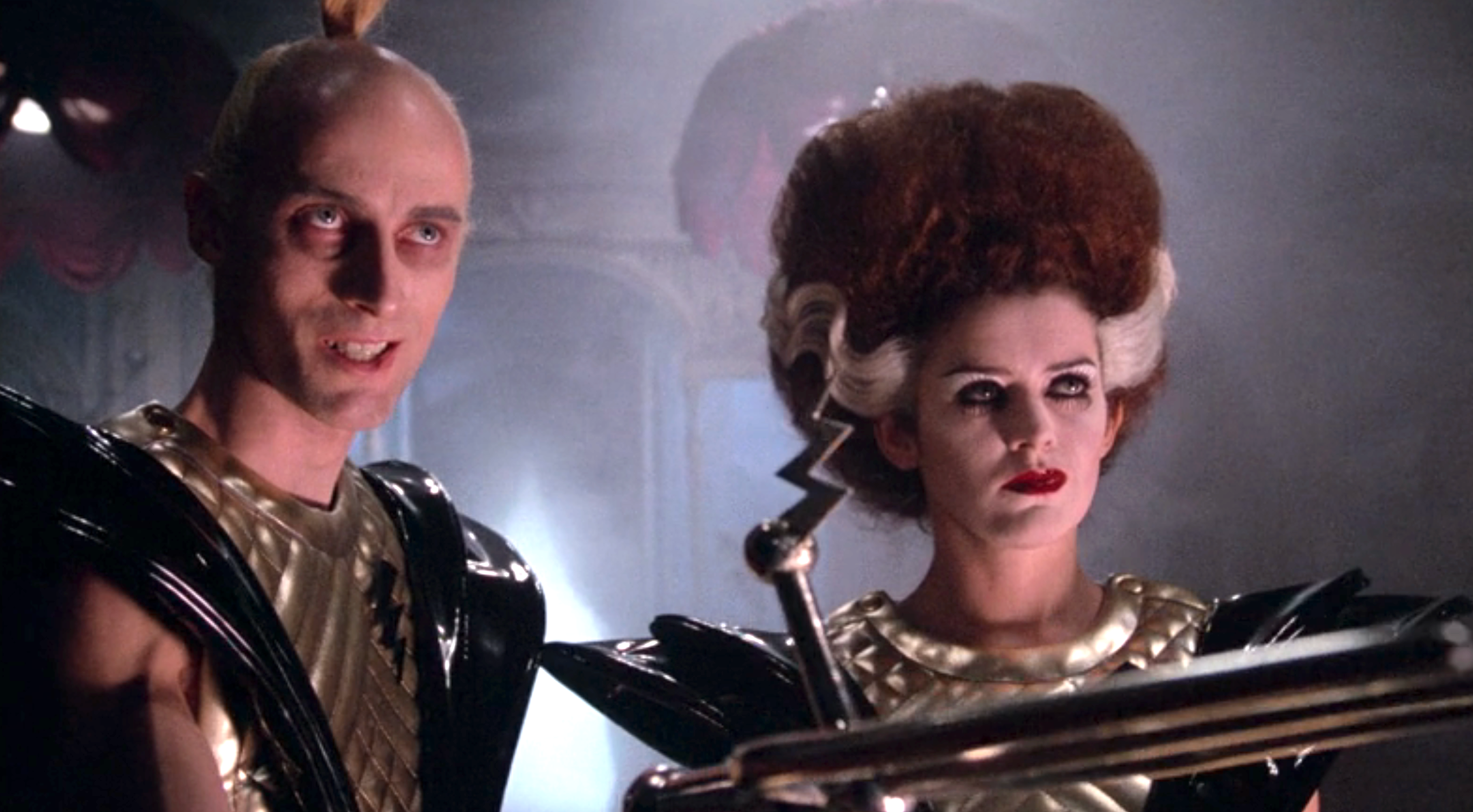 Two characters in a sci-fi setting with futuristic outfits and dramatic hairstyles. Their intense expressions convey a serious or ominous mood