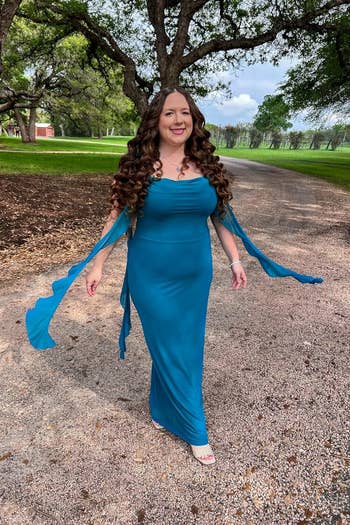 Person successful a flowing gown with long, curly hairsbreadth walks extracurricular connected a path