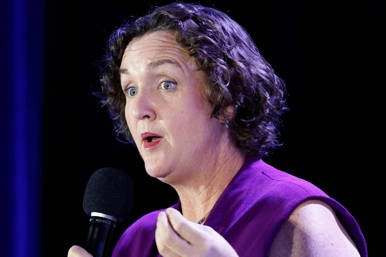 Person speaking into a microphone with an engaging expression