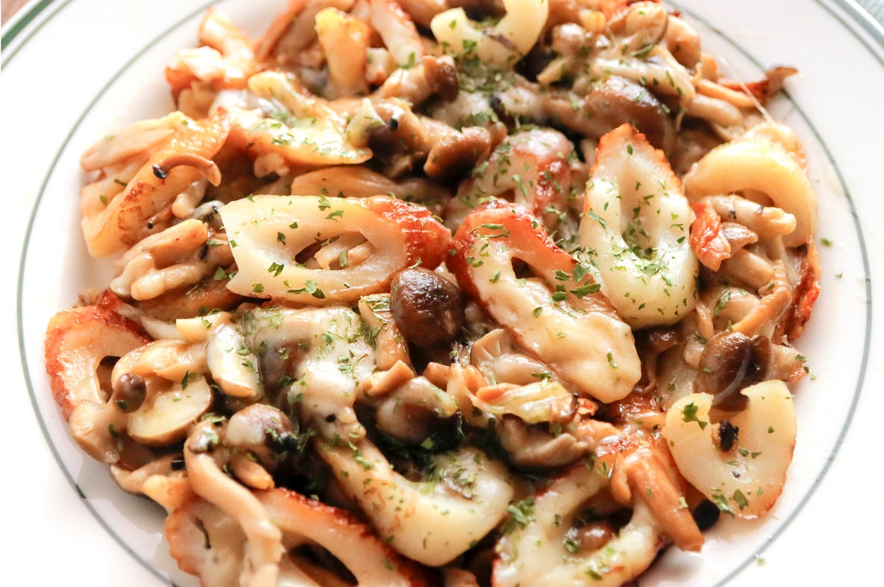 イカとキノコの炒め物が皿に盛られている。パセリがトッピングされている料理。