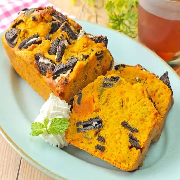 クッキーがトッピングされたパンプキンブレッドがスライスされ、クリームとミントが添えられています。
