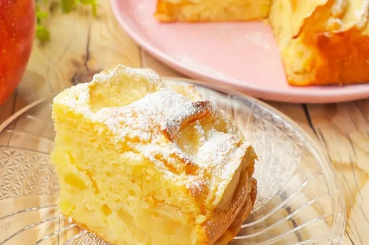 ふわふわしたスポンジケーキがガラスの皿に盛りつけられており、背景には植木とアップルがあります。