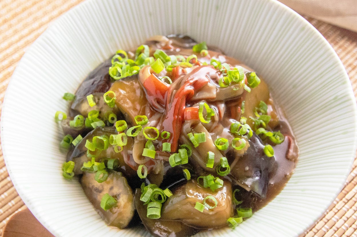 器に盛られた中華風の野菜ときのこの炒め物。上にネギが散らされています。