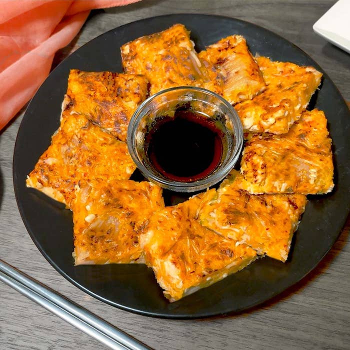 皿に盛られたキムチチヂミと中央にある小皿のたれ。
