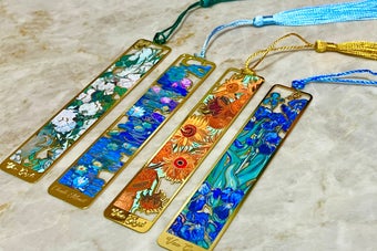 ５つの華やかなアートデザインのしおりが並んでいる。各しおりにタッセルが付いている。