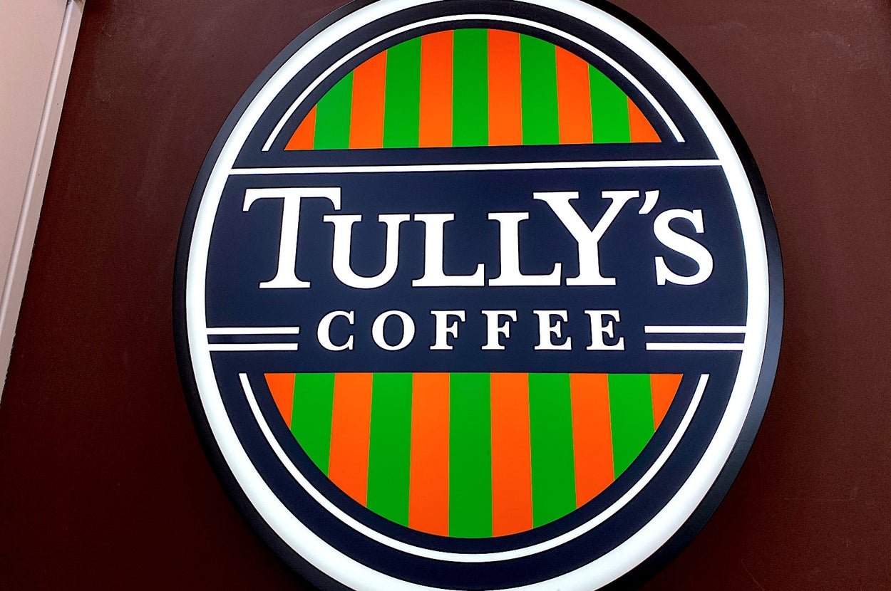 Tully's Coffee logo featuring bold text and a striped background within a circular sign