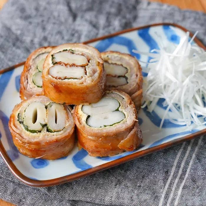 お皿に盛られた四つの肉巻き寿司ロールと千切りの大根。美しく盛り付けられ、食欲をそそる。
