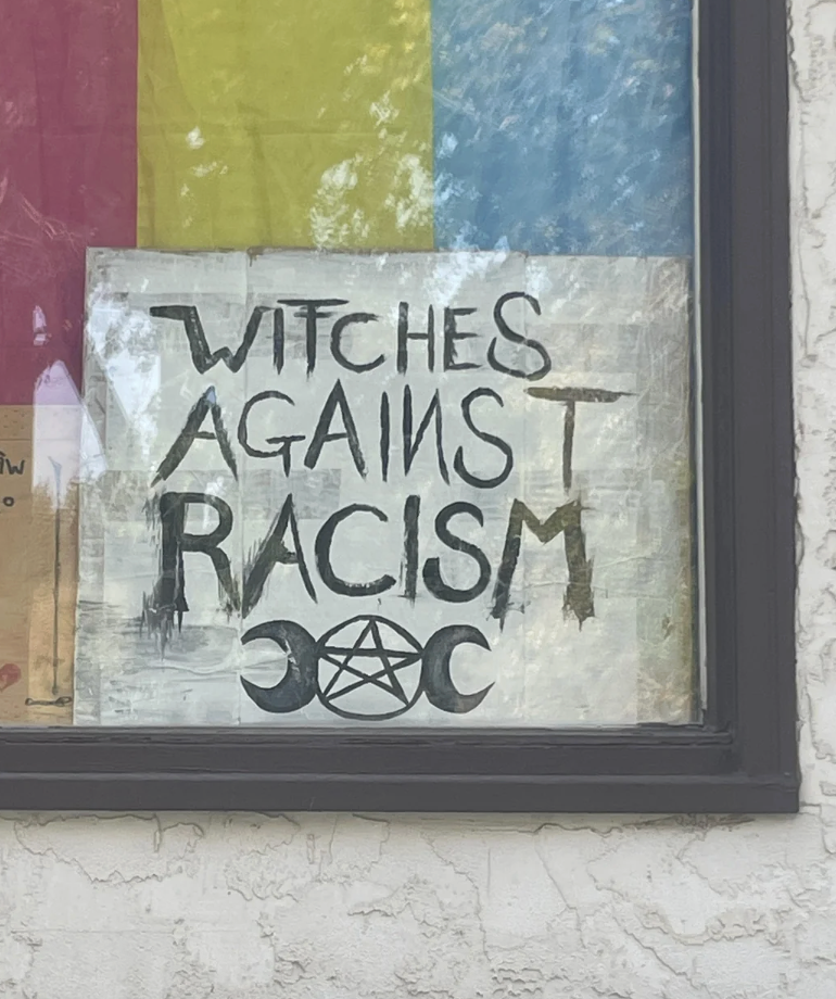  "Witches Against Racism," with crescent moons and a pentagram