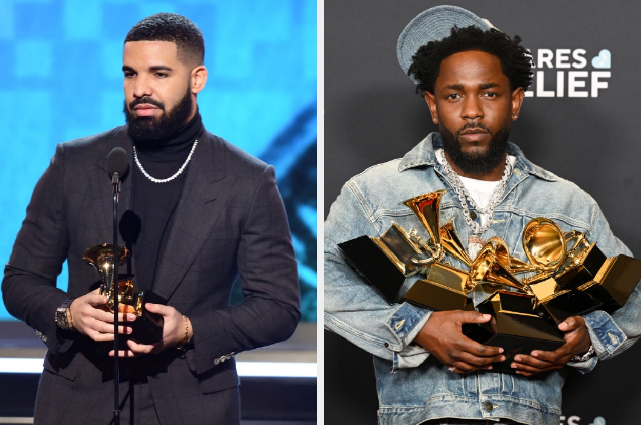 Two individuals on red carpet: left in a formal suit holding an award, right in casual denim holding multiple awards