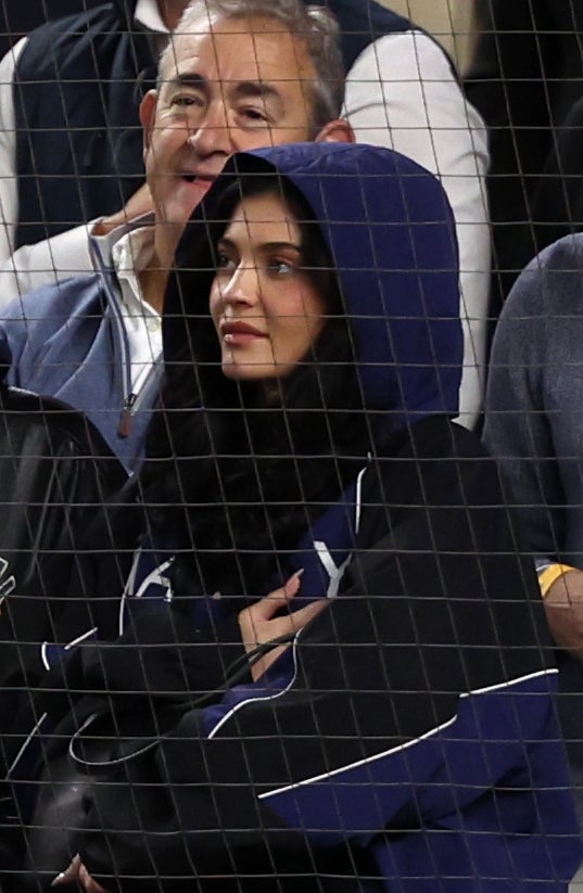 Kylie Jenner stands with a hand across her chest during a Yankees game