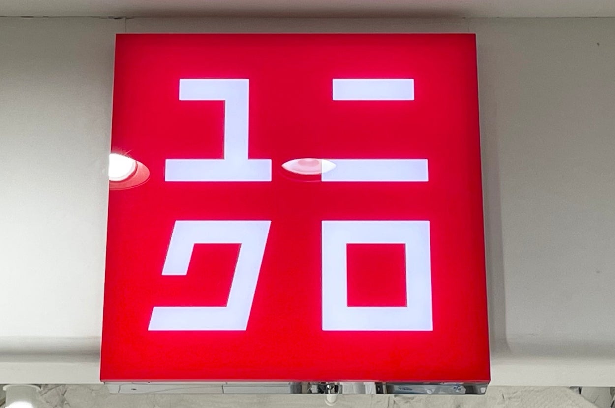 A red square sign with stylized white Japanese characters above the UNIQLO store entrance