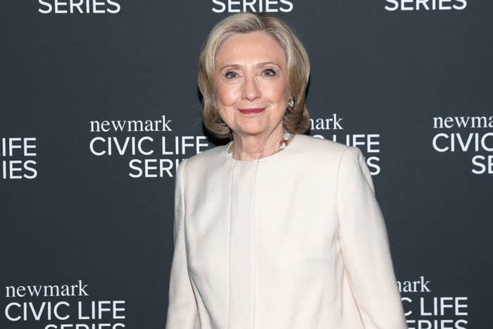 Person in an elegant suit stands at a Newmark Civic Life Series event backdrop